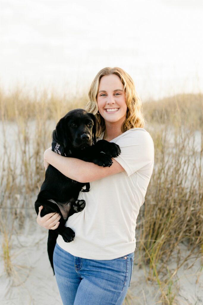 paws4people team member Cassidy Barker holding black lab puppy
