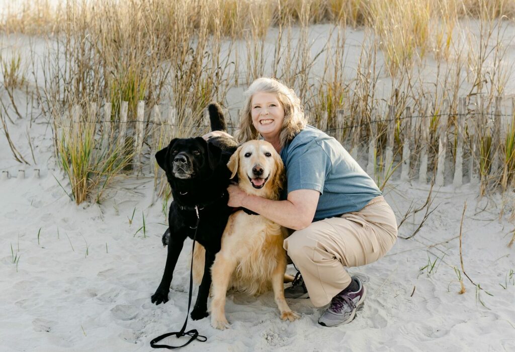paws4people team member renee johnson with black lab and yellow lab