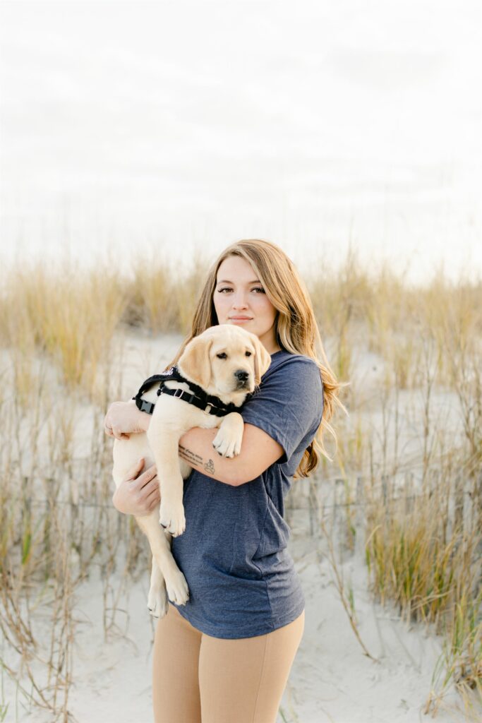 paws4people team member sara harts holding yellow lab puppy