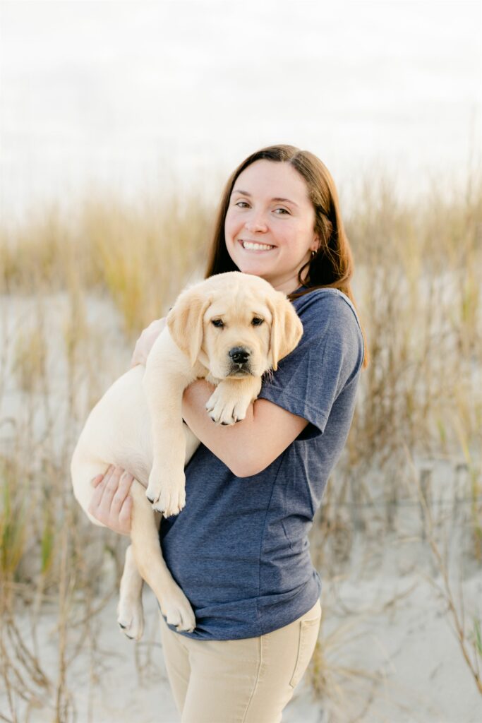 paws4people team member shannon coyle holding yellow lab puppy