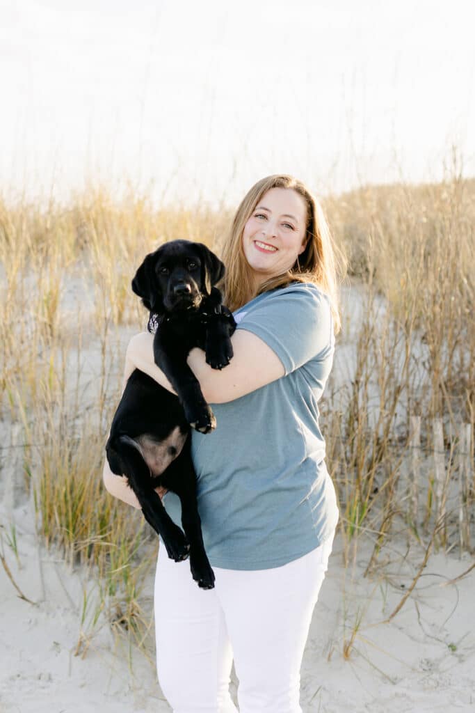 paws4people team member Ashley Currin holding black lab puppy