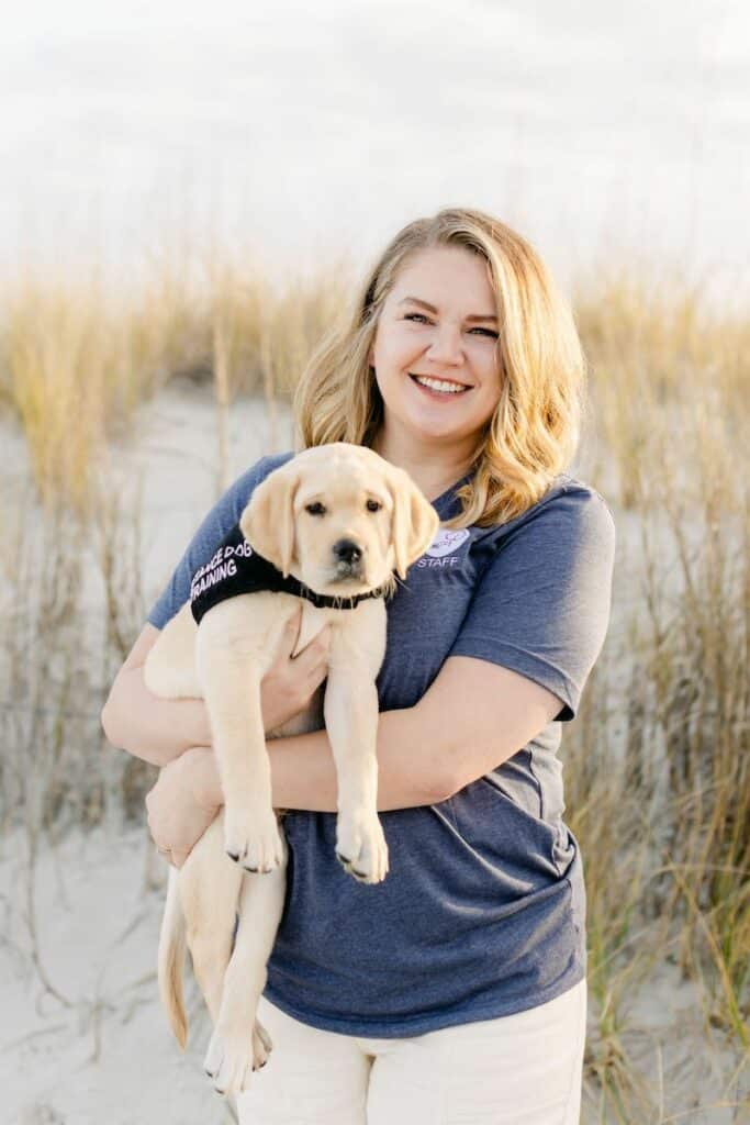 paws4people team member Elise Barret holding yellow lab puppy