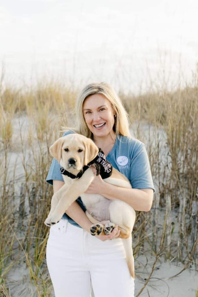 paws4people team member Melissa White holding yellow lab puppy