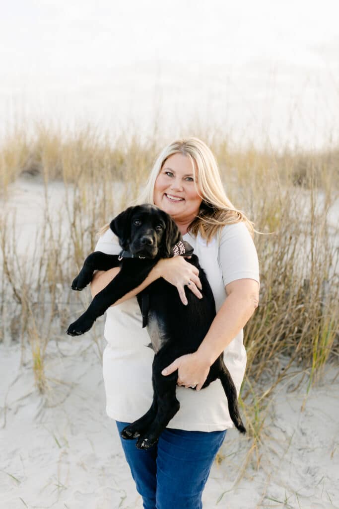 paws4people team member Tina Musselwhite holding black lab puppy